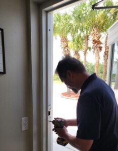 A man using a drill to open a door for the Locksmith Service.