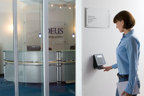 A woman is standing in front of a glass door.