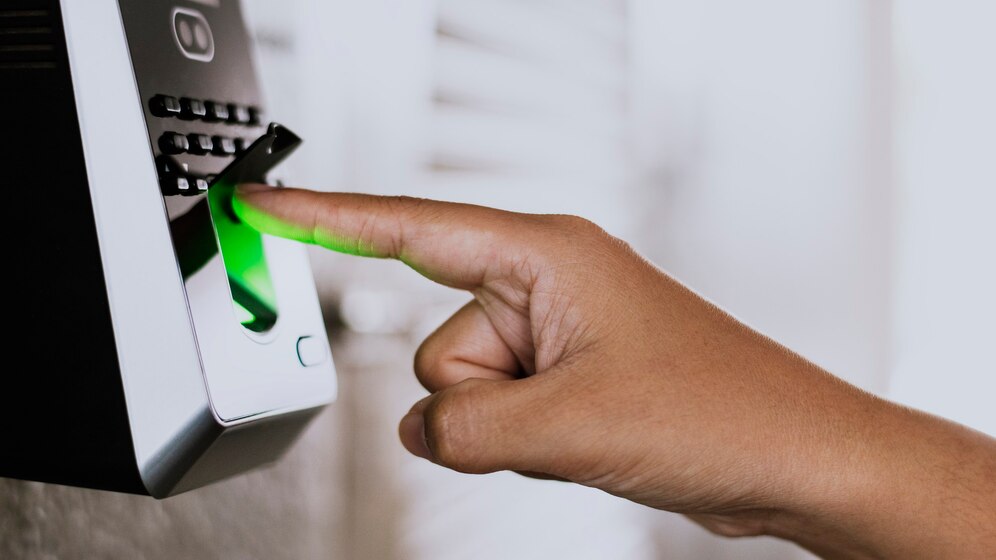A person pressing a green button on a door lock.
