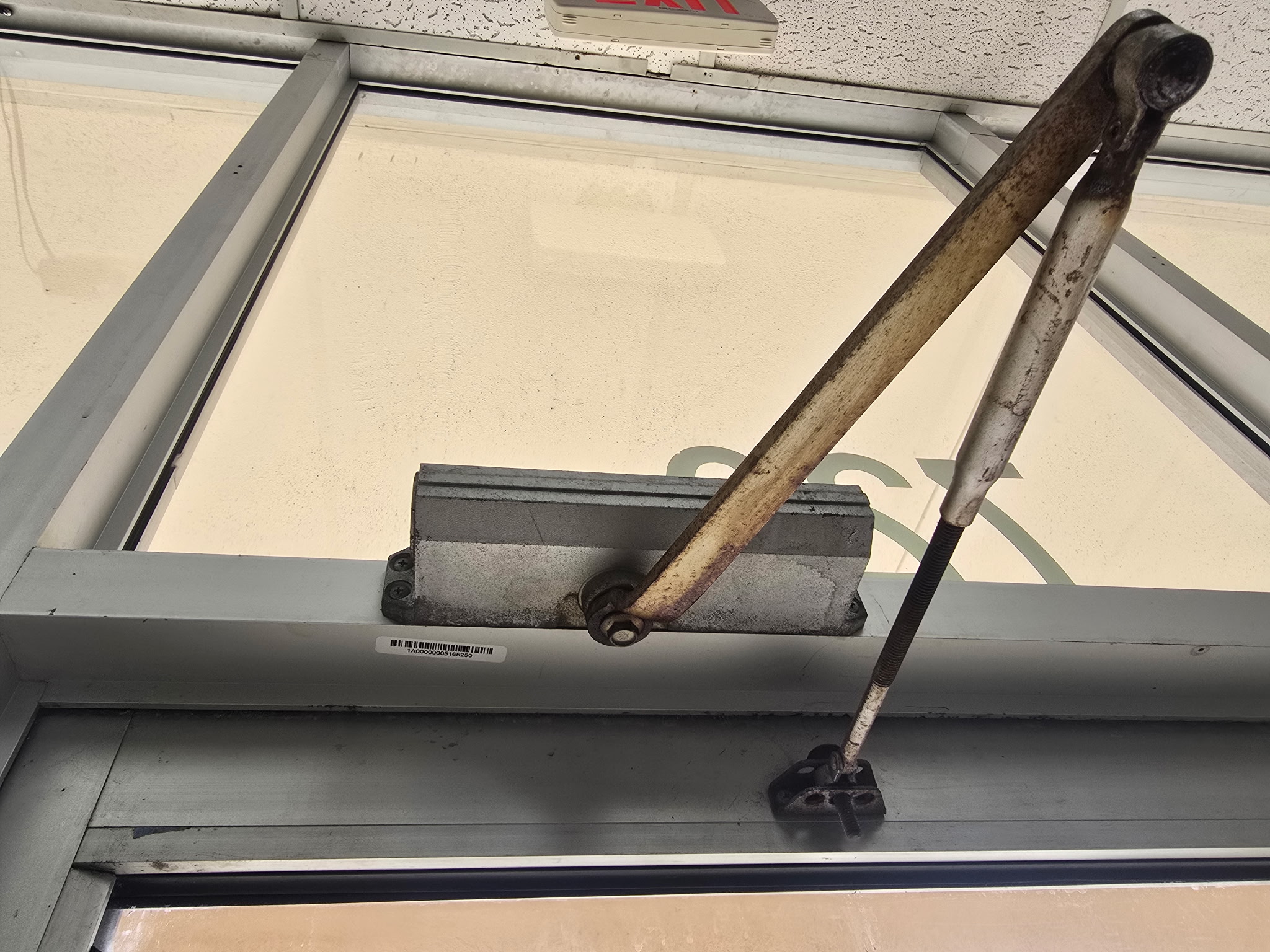 Commercial door closer showing hydraulic fluid leak — time for replacement by Key-En-Lock Brevard County FL