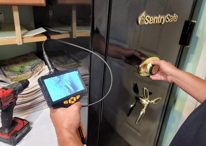 A locksmith service inspecting a safe with a camera.
