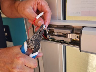 A man using pliers to open a door.